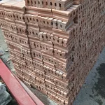 A close-up image of red clay brick, conforming to Thai Industrial Standard (TIS) 77-2565, clearly shows the pores and surface texture. It is strong and meets the standards for high-quality construction projects.