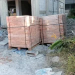 Pallets of clay bricks conforming to Thai Industrial Standard (TIS) 77-2565 are ready at the concrete building construction site, along with the standard certification.