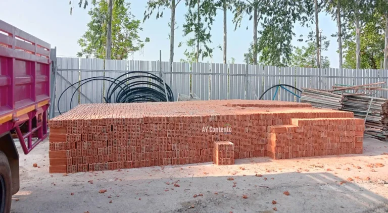 A stack of large, high-quality, 8-hole clay bricks is neatly arranged and ready for wall construction at a project site in Phan Thong District.