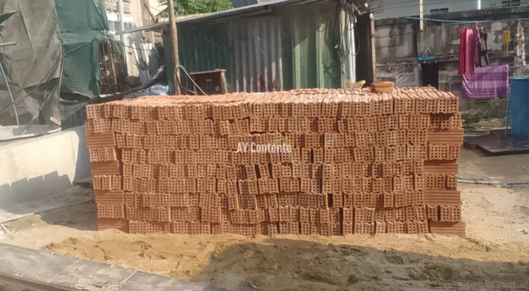 A stack of large, high-quality, 8-hole clay bricks is neatly arranged and ready for wall construction at a construction site in Klaeng District, Rayong Province.